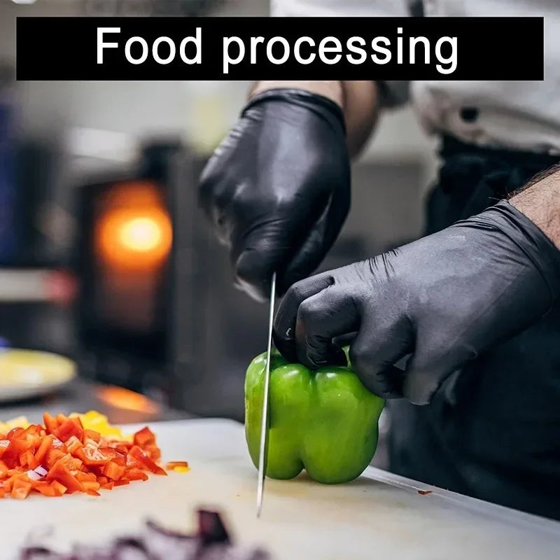 A person wearing black nitrile gloves is processing green bell peppers on a cutting board.
