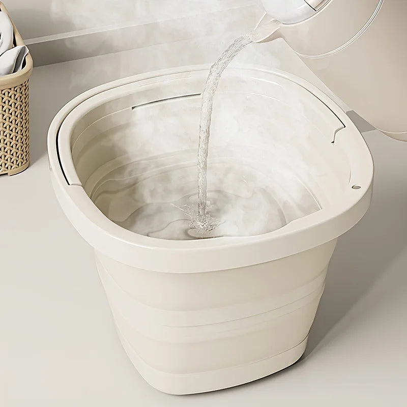 A white collapsible water bucket is shown pouring water into itself, used for camping or travel.