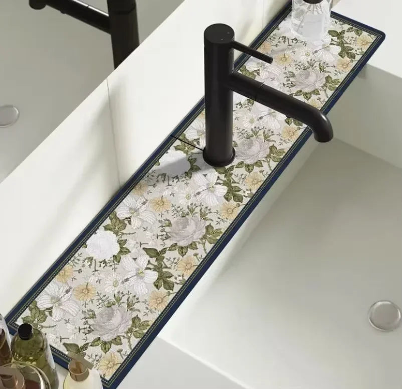 A black faucet mounted on a white countertop with a floral patterned mat.