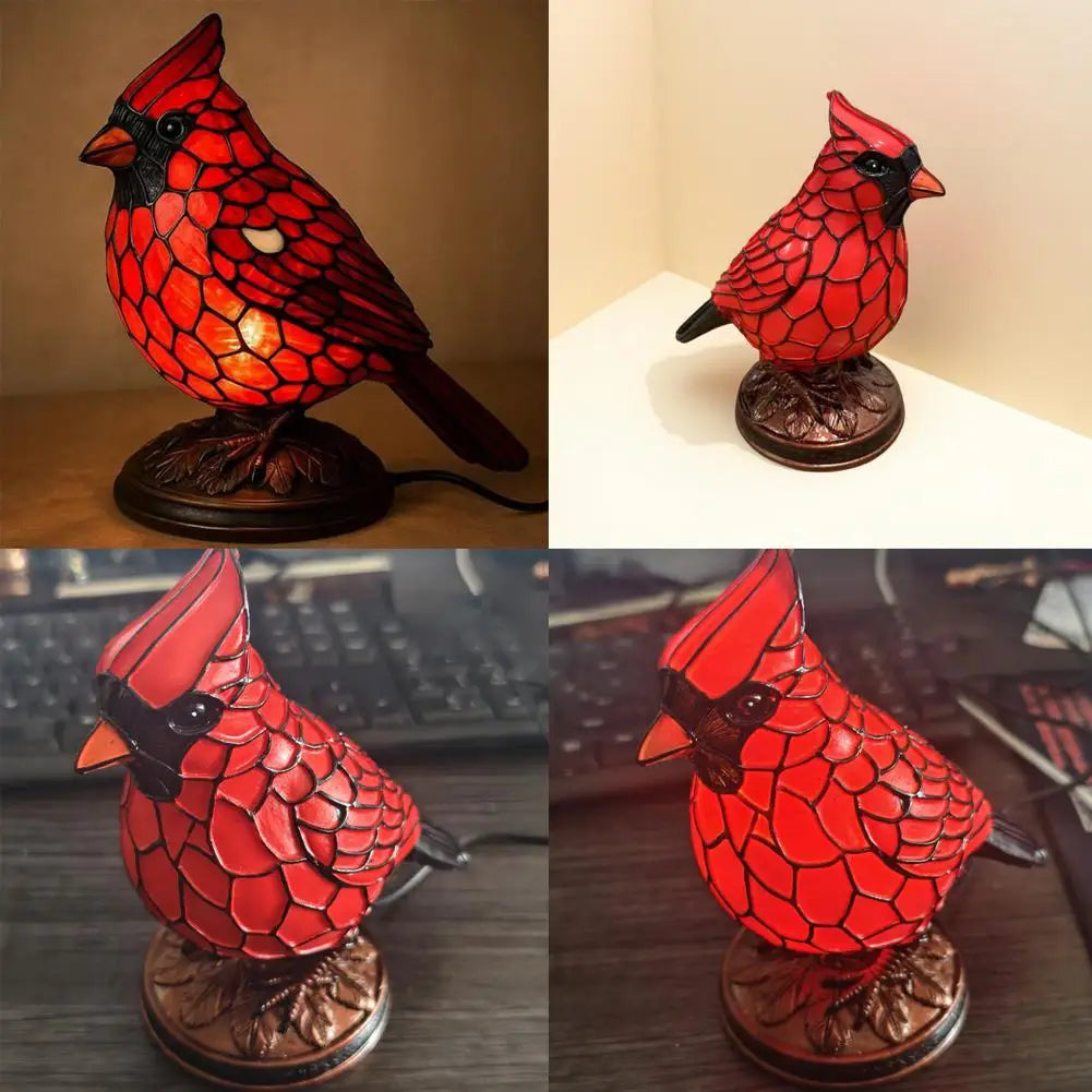A decorative resin bird table lamp shaped like a red cardinal, displayed on a wooden base.
