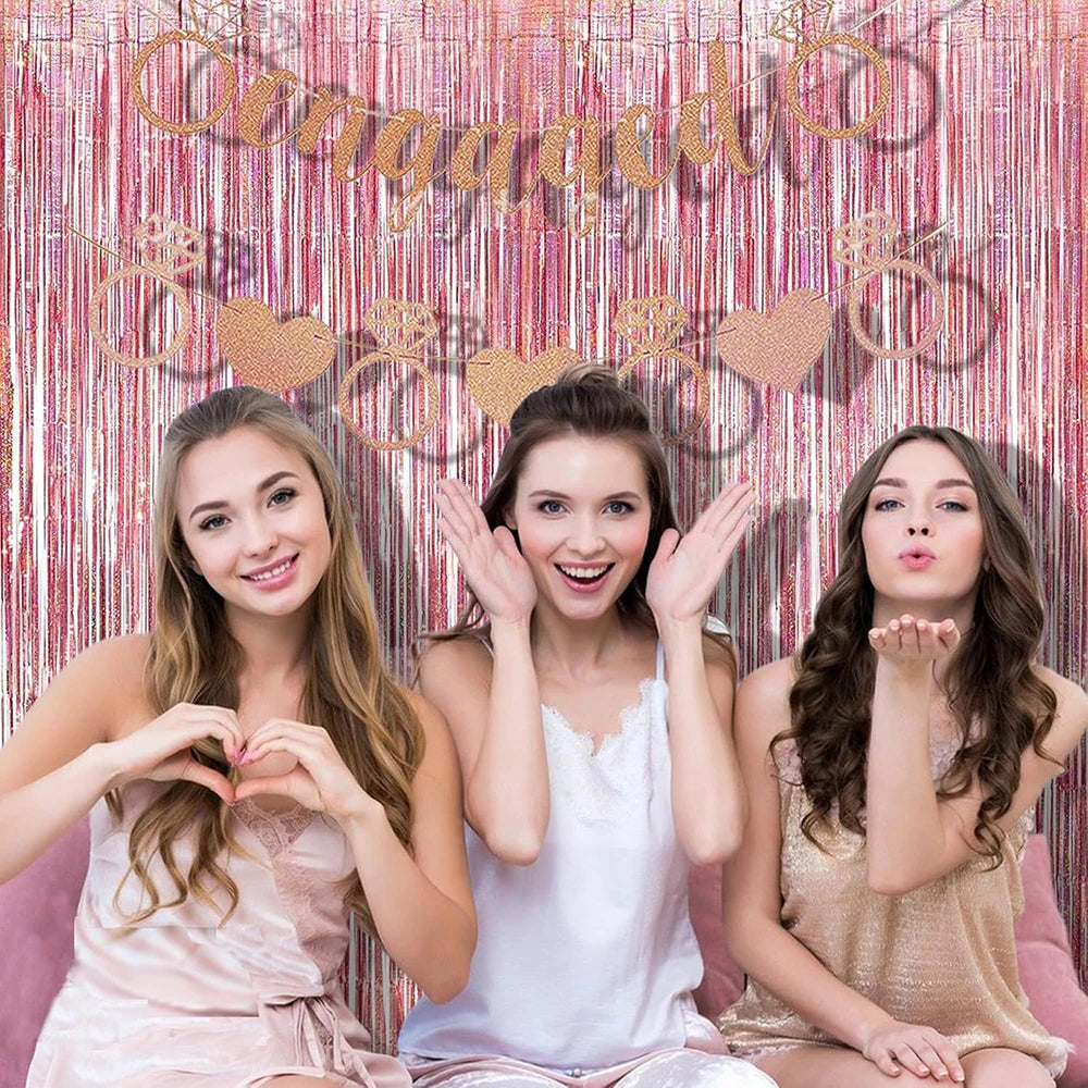 Three young women posing in front of a rose gold foil tinsel fringe curtain backdrop set