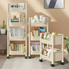 A multi-layer portable storage rack with wheels in a light beige color, featuring shelves for books and stuffed animals.