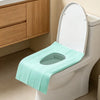 A white toilet with a light green disposable seat cover installed.