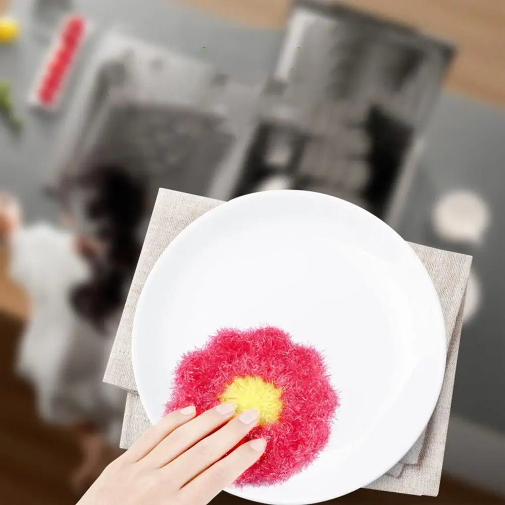 A hand places a bright pink and yellow fluffy item onto a white plate, set against a neutral napkin.