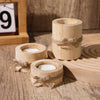 Tres portavelas cilíndricos de madera natural atados con cuerda sobre una superficie de madera.