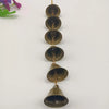A vertical arrangement of vintage metal wind chimes with brass chains and dome-shaped metal bowls.