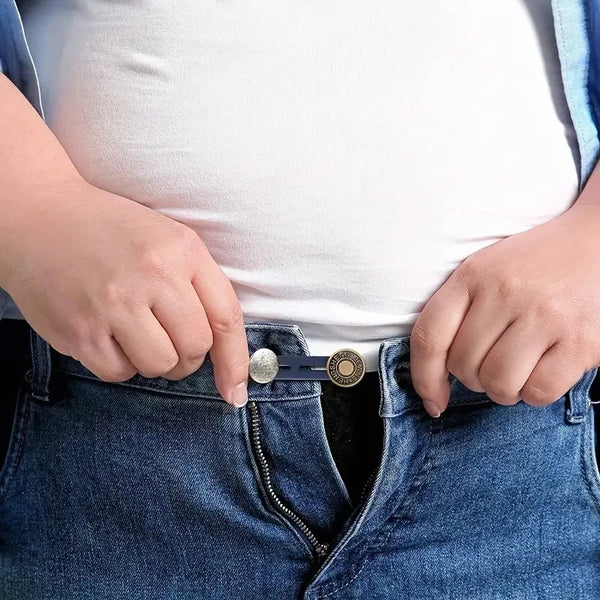 Hands inserting metal buckle extenders into the pocket of blue jeans.