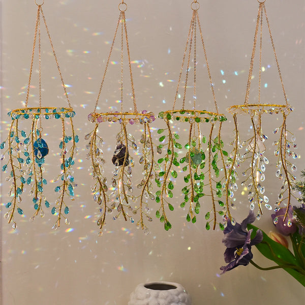 A hanging crystal wind chime suncatcher featuring clear glass beads and green leaves with purple flowers.