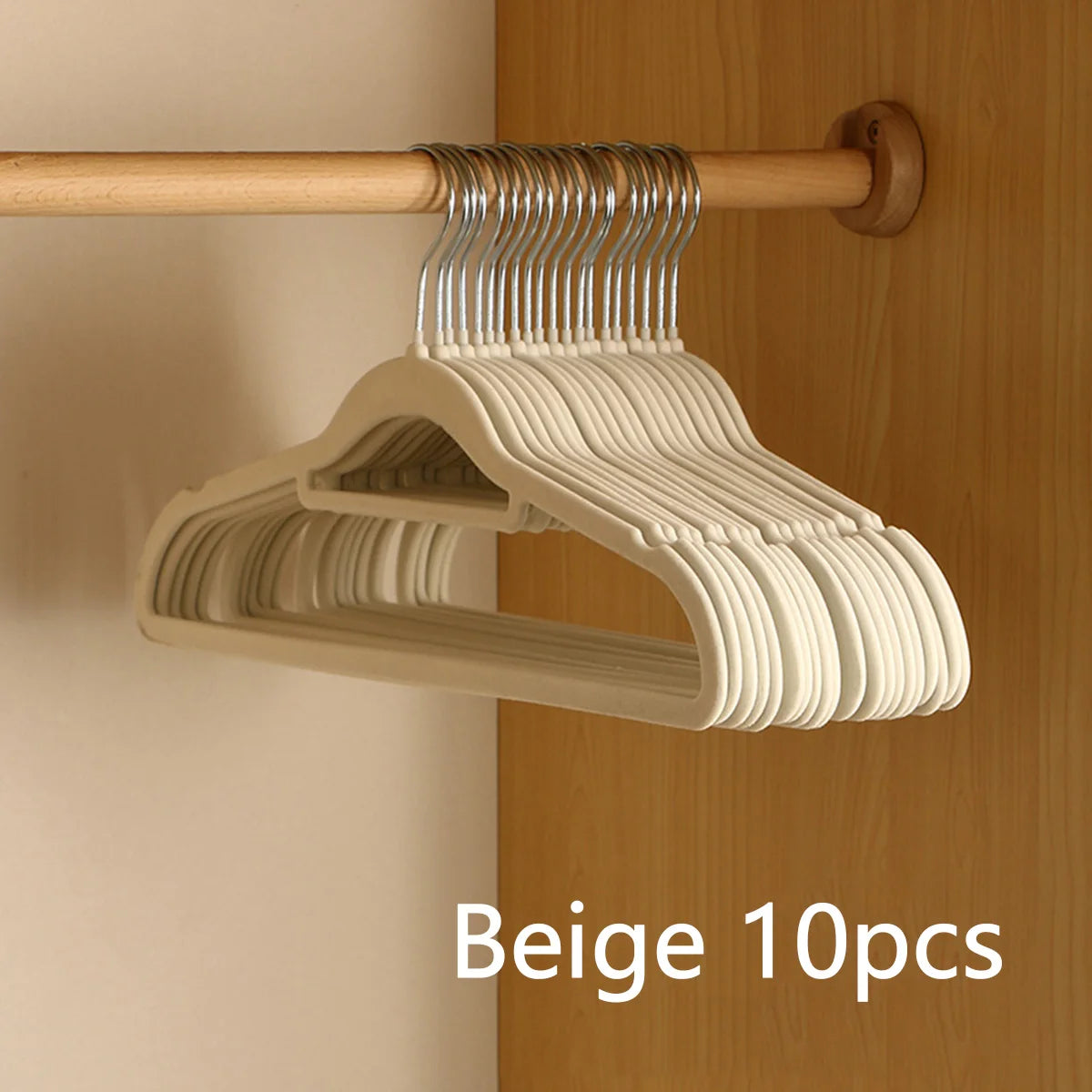 Beige velvet slim hangers on a wooden rod mounted on a cabinet door.
