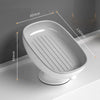 A white suction cup soap dish with built-in drainage features and measurement lines.