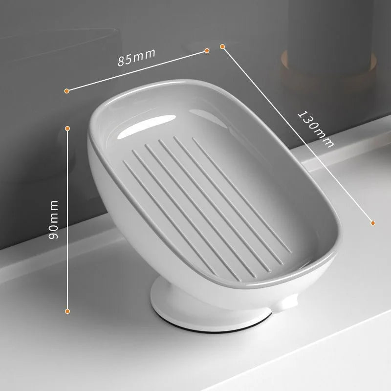 A white suction cup soap dish with built-in drainage features and measurement lines.