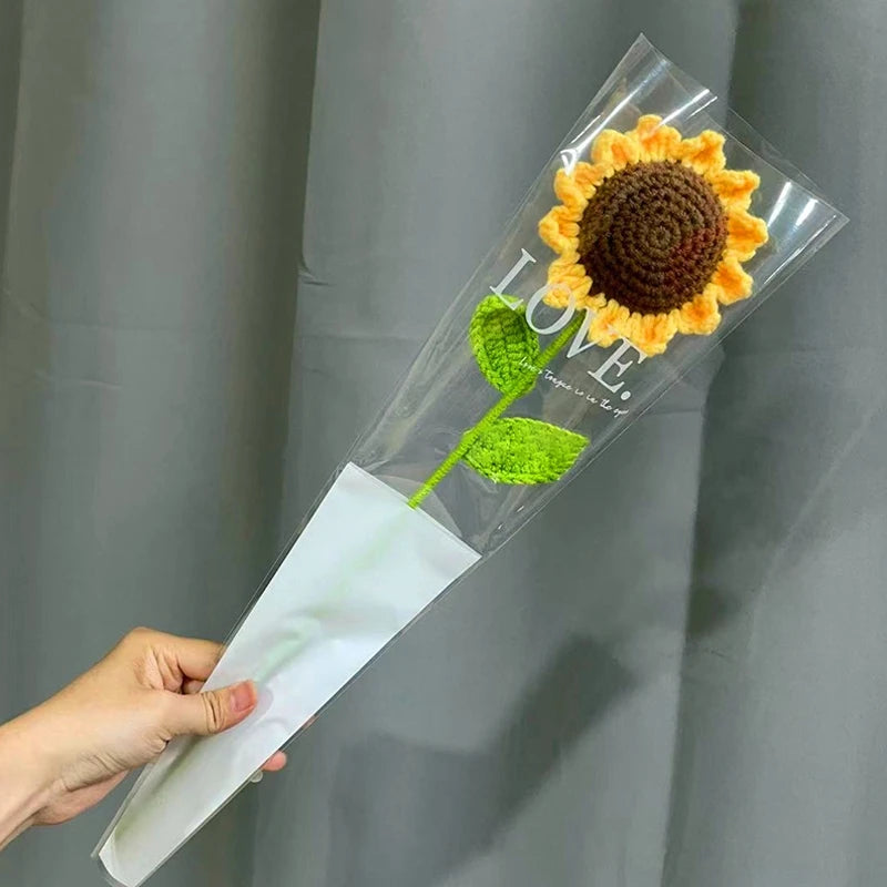 Bouquet de fleurs de carnation en coton fait main, emballé dans du plastique transparent et du papier de soie.