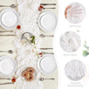 A white linen table setting featuring a sheer fabric runner, plates, silverware, and floral accents.