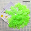 A pile of green glow in the dark 3D star wall decals, with packaging showing usage instructions.