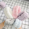 A collection of soft, fluffy microfiber wrist sweatbands in various pastel colors including pink, lavender, white, and light 