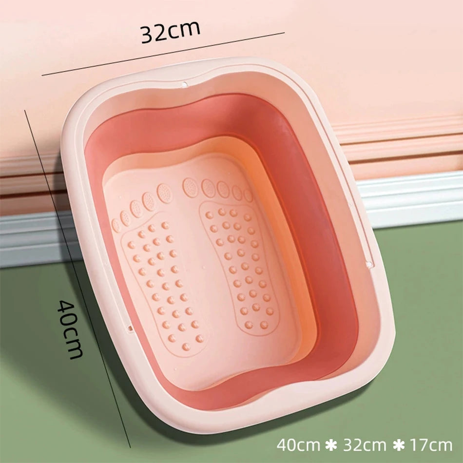 A pink portable foot bath tub with a rectangular shape and textured interior is shown on a green surface.