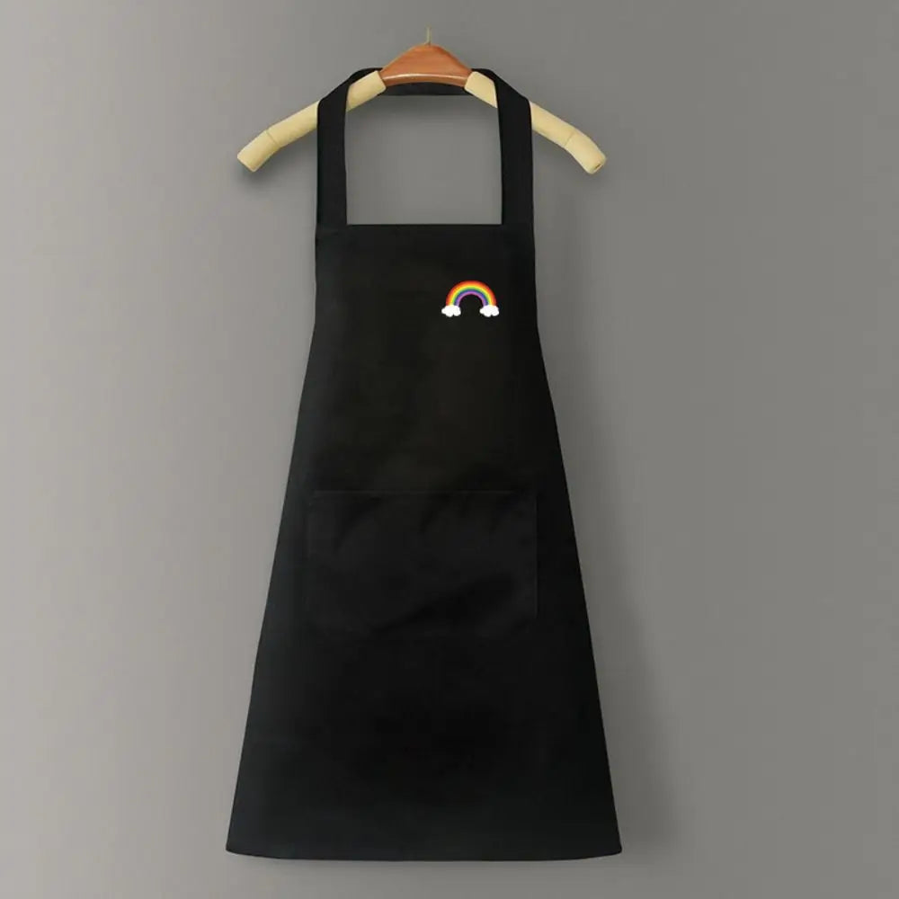 A black chef apron with a large front pocket and a rainbow embroidered on the chest.