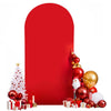 A red arch backdrop decorated with Christmas ornaments and gifts.