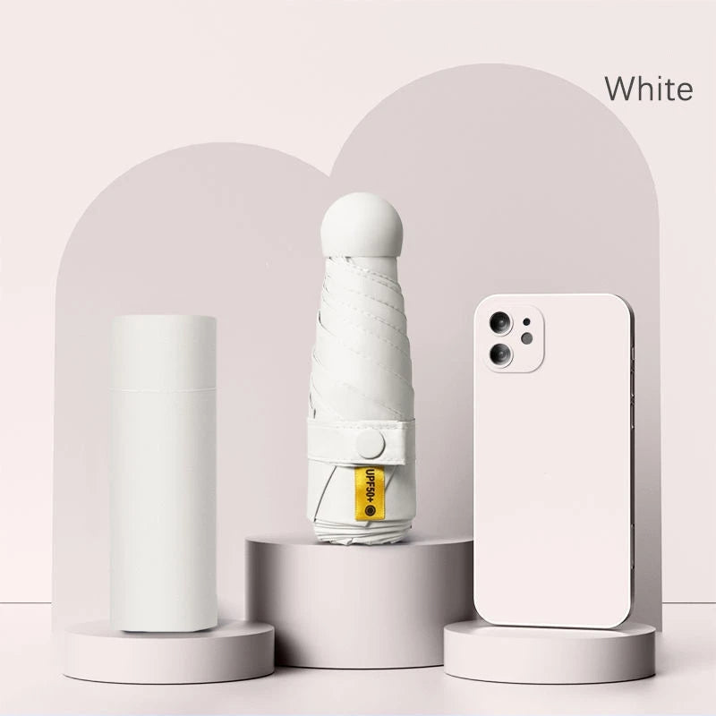 A white folding UV protection umbrella and a white smartphone are displayed on a light pink background.