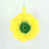 A bright yellow, fluffy flower-shaped dish towel with a green center.