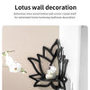 Decoración de pared de loto de madera negra con una orquídea blanca en un estante.