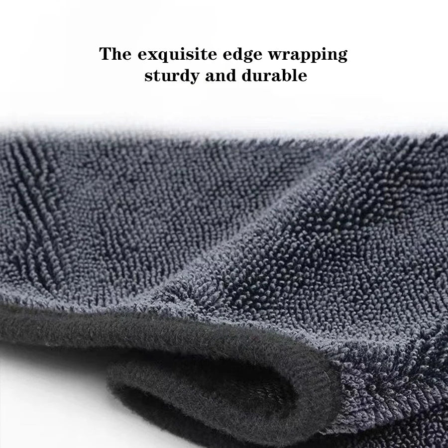 A close-up of a dark gray microfiber car cleaning towel rolled up, showing its textured surface.