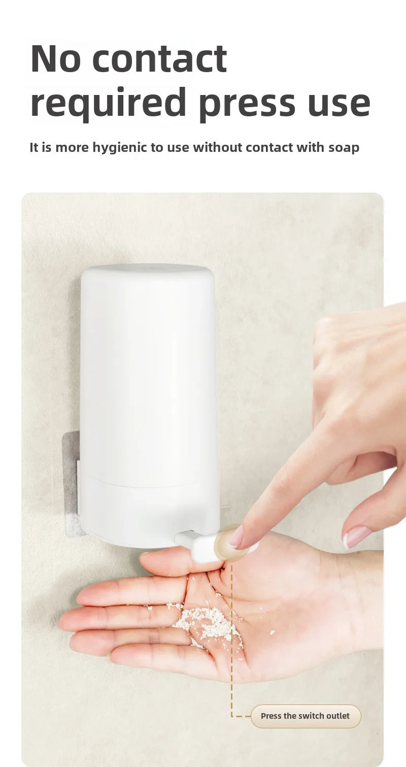 A hand is pressing the switch outlet on a white portable soap bar grinder with a wall-mount design.