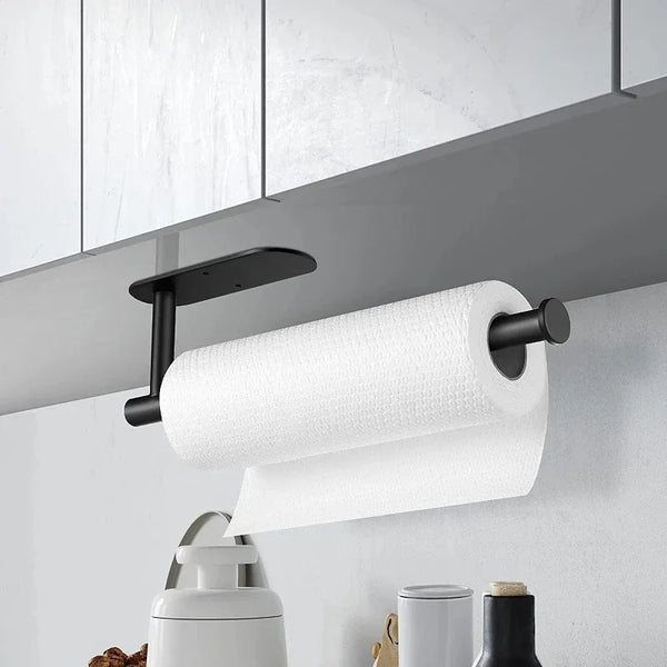 A white roll of paper towels mounted on a black adhesive wall mount above a kitchen counter.