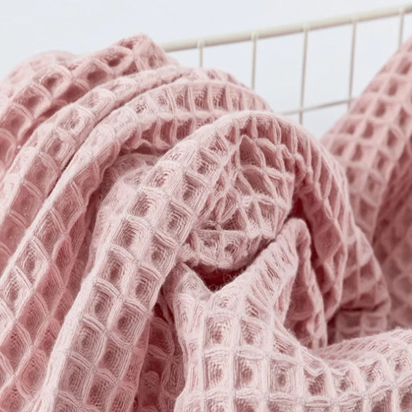 Nahaufnahme eines rosa Luxus-Baumwoll-Waffeltuchsets, drapiert und gefaltet.