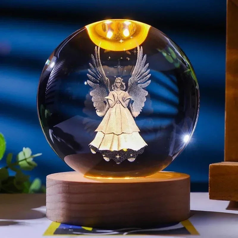 An illuminated crystal ball set featuring a figure with large wings and a glowing golden light.