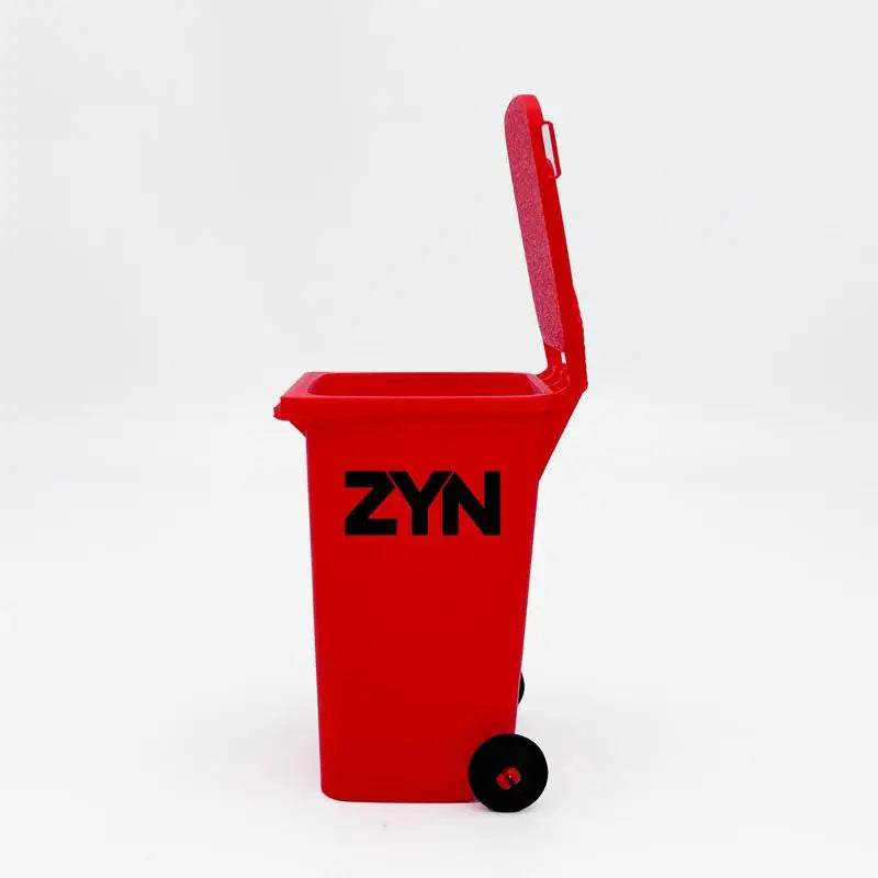 A red mini desk organizer trash can with a black lid and wheels.