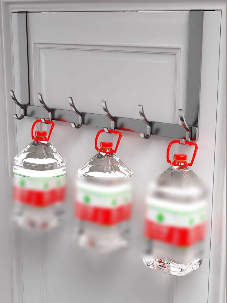 A white over-the-door organizer rack with extended arms holding three clear water bottles.