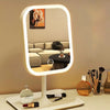 An LED desktop vanity mirror with adjustable lighting is displayed on a white surface.