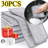 A stack of 30 pieces of gray metal wire cleaning cloths, with one cloth being used to clean a black pan.