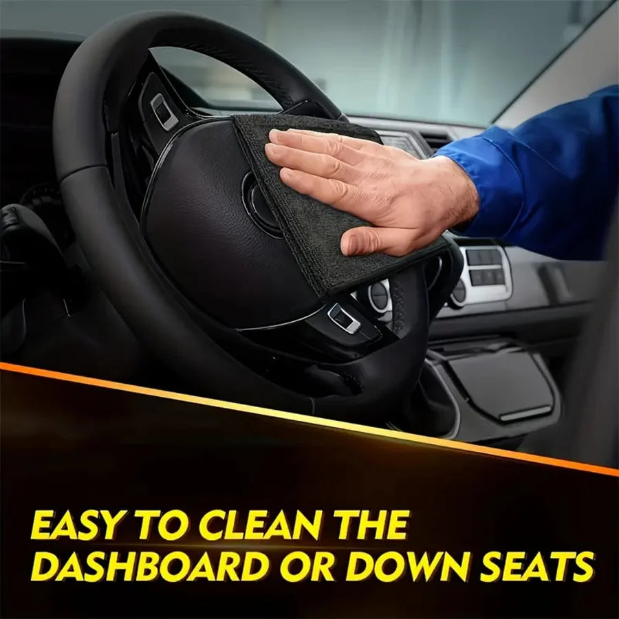 A hand wipes a car steering wheel with a black microfiber cloth, demonstrating easy cleaning for the dashboard or down seats.
