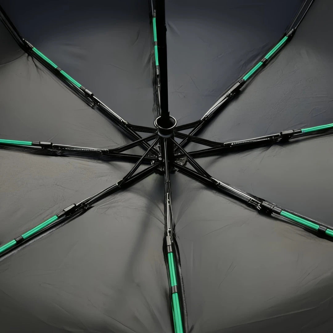 A black heavy duty automatic windproof umbrella with green accents, viewed from above.