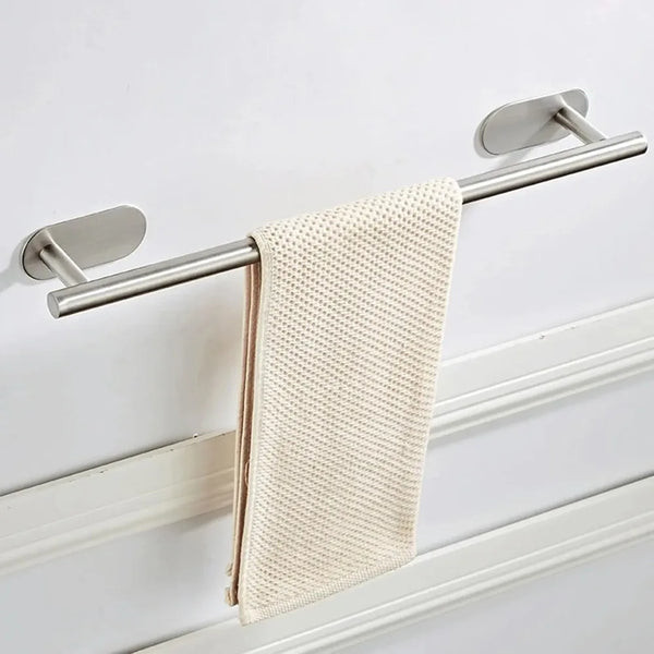 A stainless steel towel bar with a beige woven towel hanging on it.