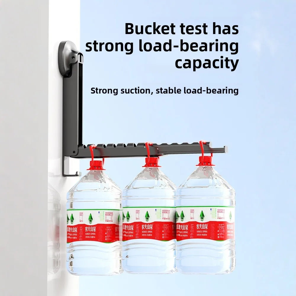 A black foldable wall drying rack with three clear plastic bottles attached using strong suction cups.