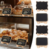 A set of mini wooden chalkboard signs with food illustrations displayed on a glass tray.