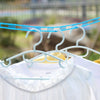 A white shirt is hanging on a clothesline with blue plastic hangers and rope.