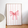 Pink striped canvas wall art featuring a bow design for nursery decor
