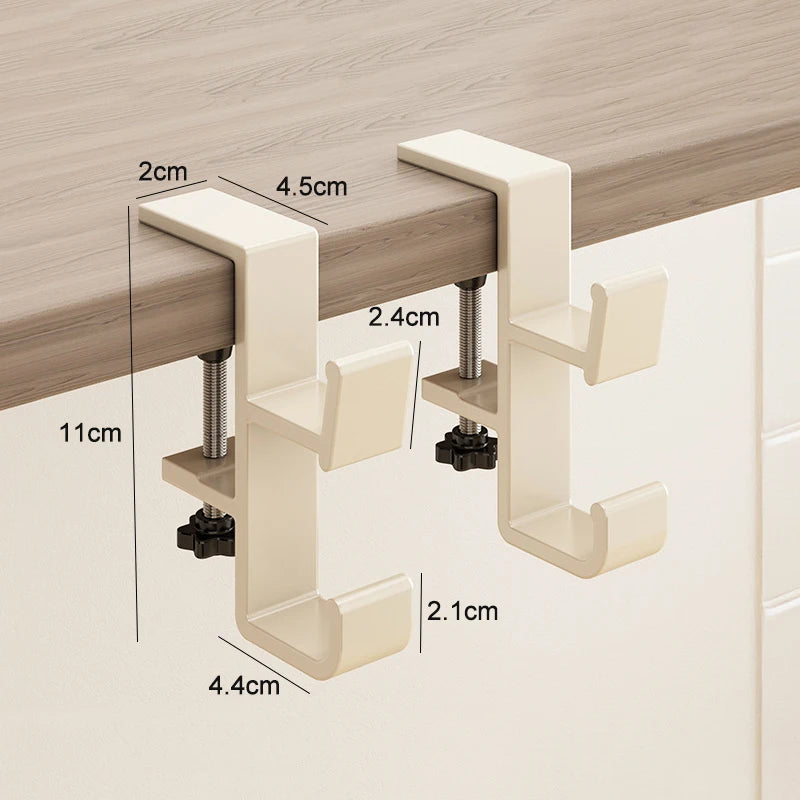 A beige adjustable desk hook hanger mounted on a wooden surface, showing various dimensions for installation.