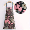 A dark floral print kitchen apron featuring pink and gray flowers with a large circular detail.