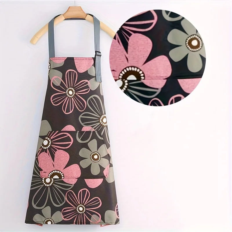 A dark floral print kitchen apron featuring pink and gray flowers with a large circular detail.