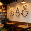 Un juego de tazas de café de hierro negro para decoración de pared, montadas en una pared blanca.