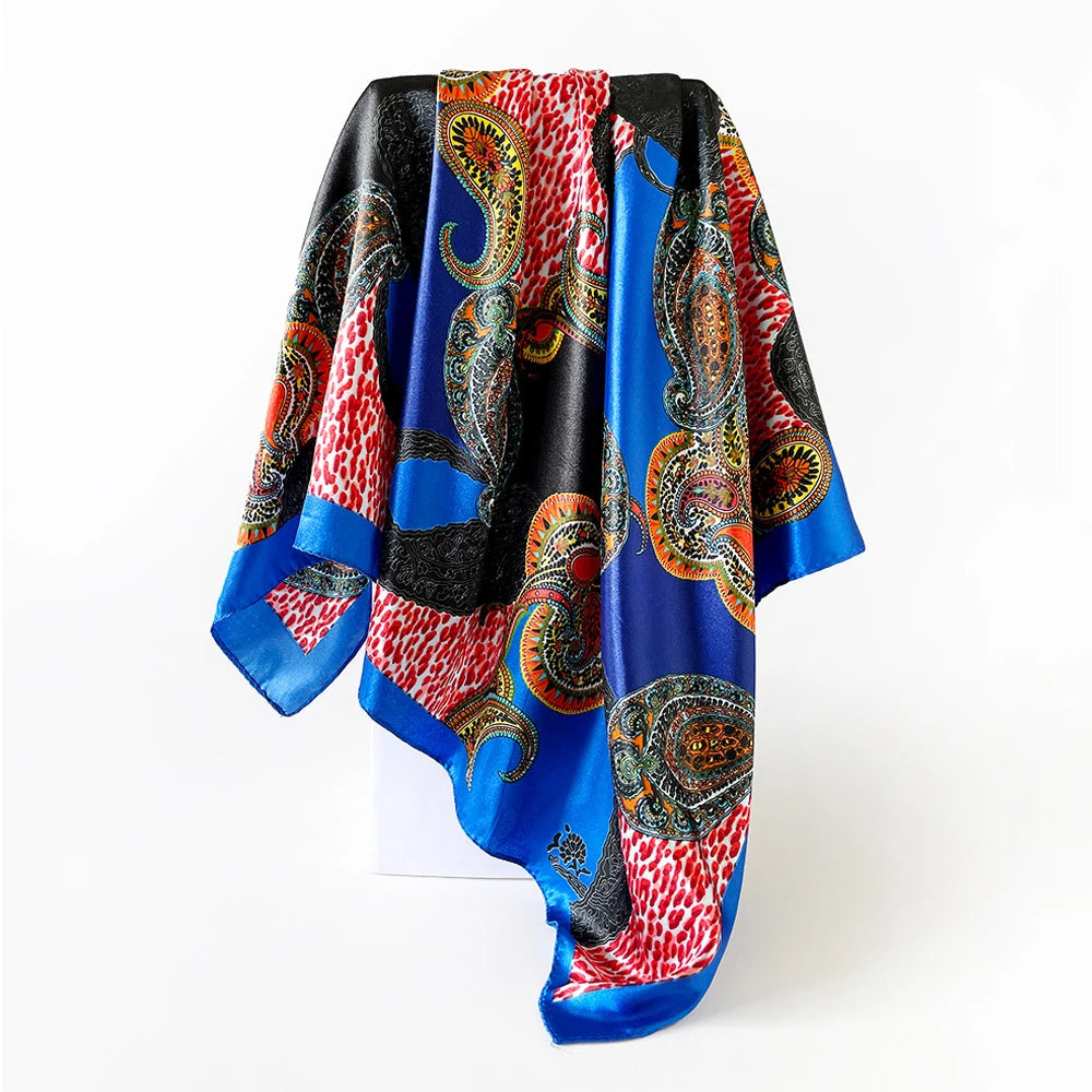 A vibrant blue and red paisley print scarf draped on a white surface.