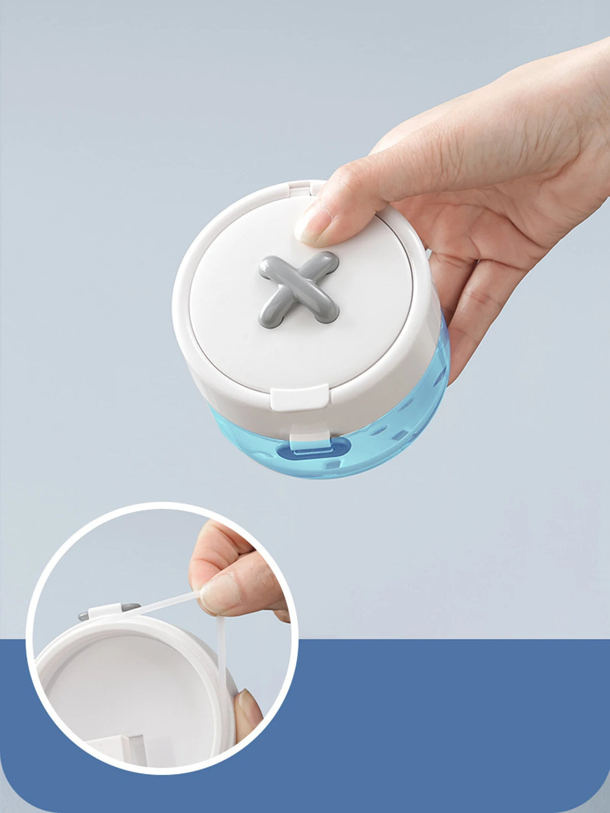 A hand is holding a clear plastic container with a white lid and a gray cross-shaped opening, demonstrating the portable mult