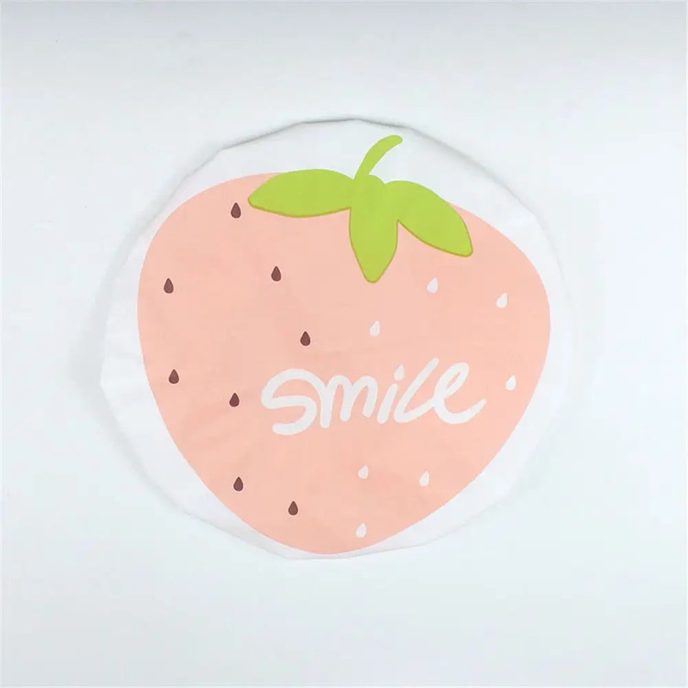 A reusable fruit shower cap shaped like a strawberry with a green leaf and the word smile on it.