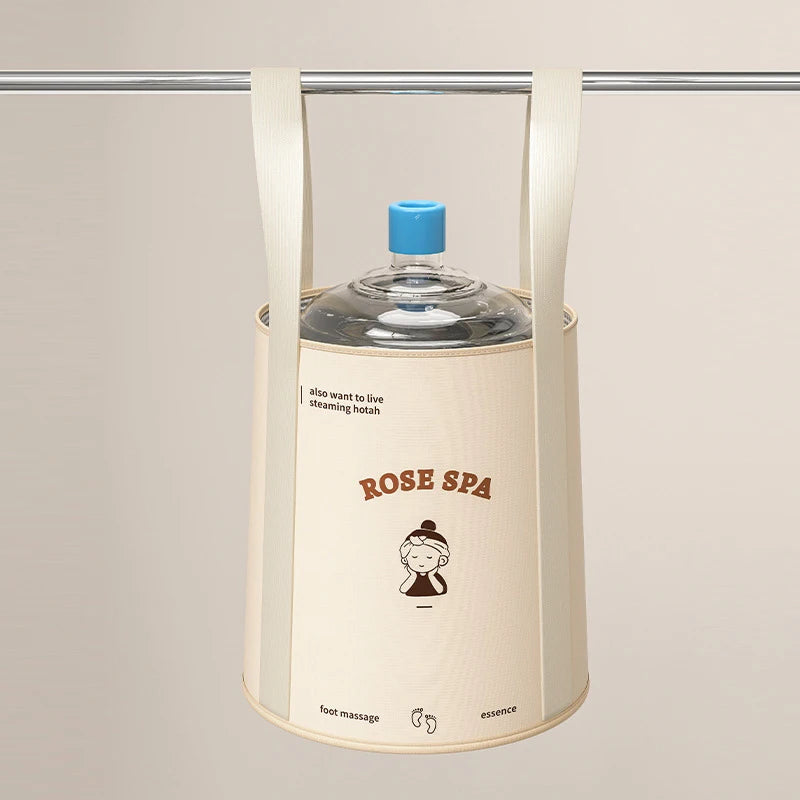 A beige foldable aluminum foot bath bucket hanging from a bar, with a blue cap visible.