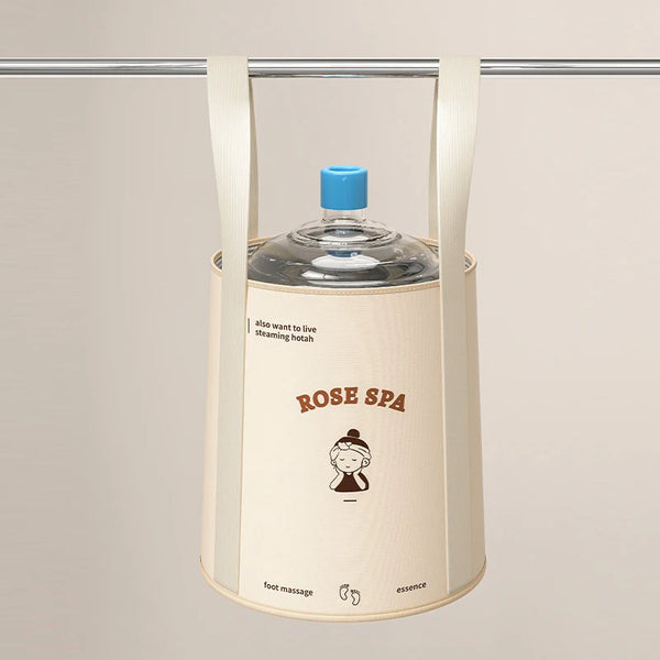 A beige foldable aluminum foot bath bucket hanging from a bar, with a blue cap visible.